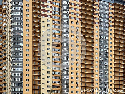 Background texture: multi-storey new house. Tall yellow-gray building in a new area. Concept: real estate investment, mortgage, Stock Photo