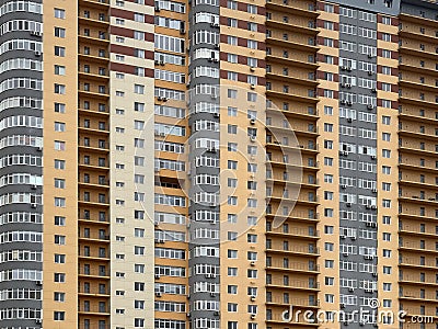 Background texture: multi-storey new house. Tall yellow-gray building in a new area. Concept: real estate investment, mortgage, Stock Photo