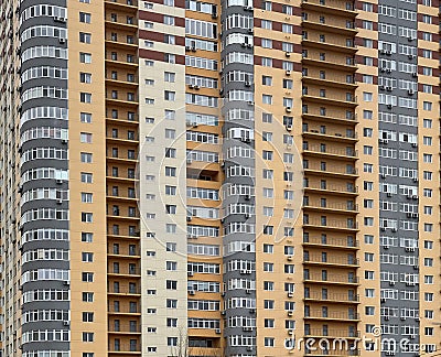 Background texture: multi-storey new house. Tall yellow-gray building in a new area. Concept: real estate investment, mortgage, Stock Photo