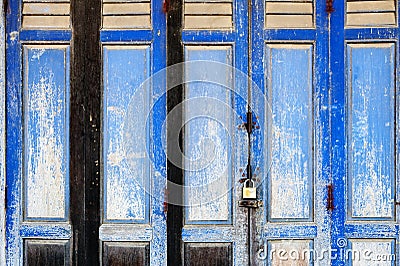 Background texture on old rustic blue wooden folding door of classic Sino-Portuguese architectural style shophouse building Stock Photo