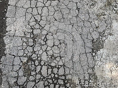 A background texture plot of old city road smashed by car wheels into set small pieces of grey with black contour of wet earth Stock Photo