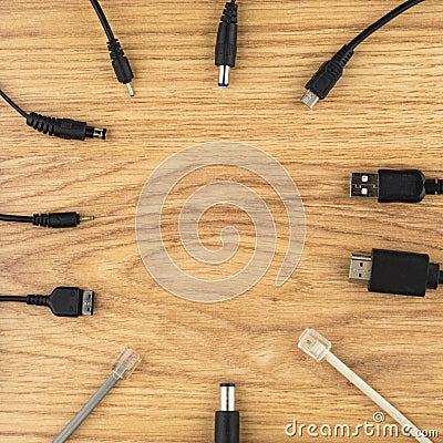 The background with the theme of technology: lots of different plugs and charger on a wooden table Stock Photo