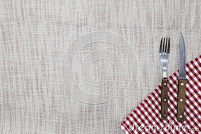 The background to create the restaurant`s menu. Linen tablecloth fork knife on a bright checkered cloth. Is used to create a menu Stock Photo