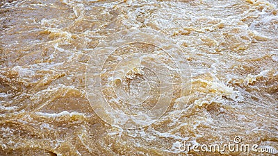 Background of turbid brown tidal wave surface which turbulently floods the overflow weirs Stock Photo