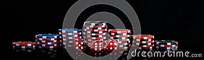 Background vertical rows of different poker chips and red dice stand on a black background long photo Stock Photo