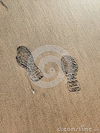 Footprints of human on wet sand. Beach sand seamless background. Stock Photo