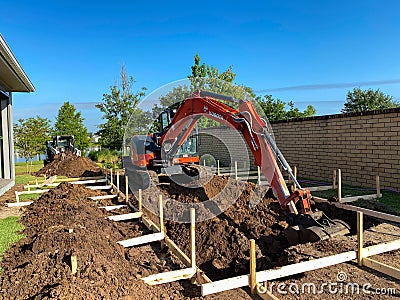 A backhoe digging a hole for a pool behind a house in Orlando, Florida Editorial Stock Photo