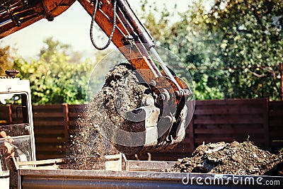 Backhoe excavator moving earth on construction site Stock Photo