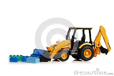 Backhoe tractor with brick toys, white background Stock Photo