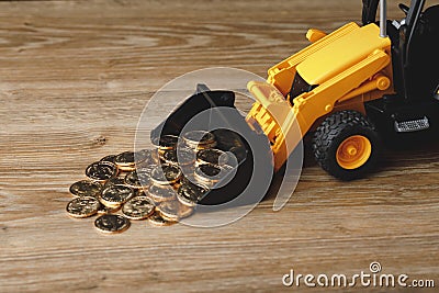 Backhoe tractor rake up money coins Stock Photo