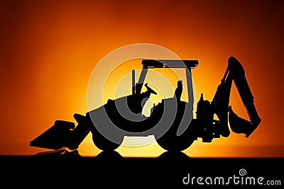 Backhoe tractor silhouette, orange background Stock Photo