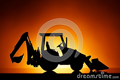 Backhoe tractor silhouette, orange background Stock Photo