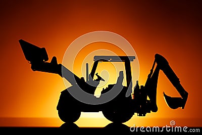 Backhoe tractor silhouette, orange background Stock Photo