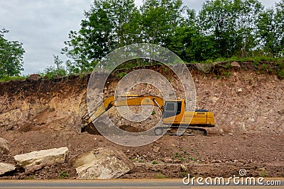 Backhoe working on hill side road Stock Photo