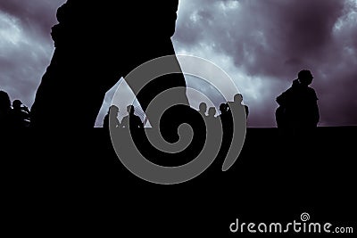 Backlight of a cloudy day with a silhouettes of a group of unrecognizable people Stock Photo