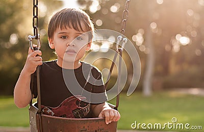 Backlit boy on swing Stock Photo