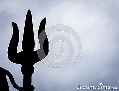 backlit isolated shot of hindu god shiva trident with dramatic background Stock Photo