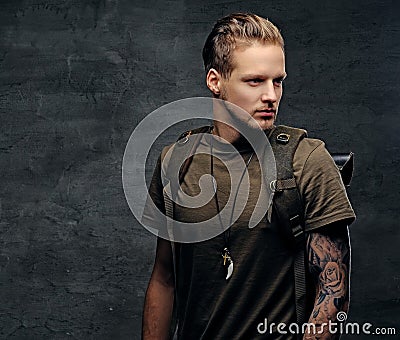 Backpacker in Camo green t shirt and tattoos on arms. Stock Photo