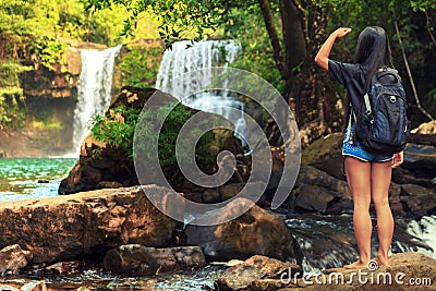 Young beautiful woman in bikini explore waterfall hidden in the tropical jungle on background amazing wild tropical nature Stock Photo