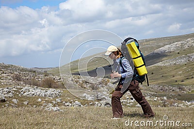 Backpacker girl traveling in mountains Stock Photo