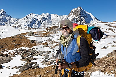 Backpacker mountaineer man portrait standing rest snow mountain. Stock Photo