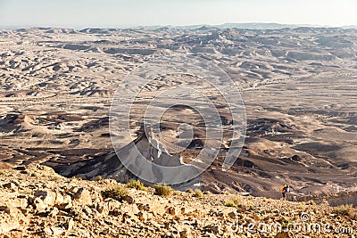 Backpacker mountaineer tourist ascending stone desert mountain slope Stock Photo