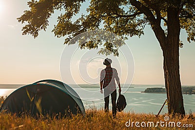 Backpacker posing on seashore with tent Stock Photo