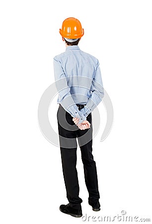 Backview of an engineer in construction helmet stands. Stock Photo