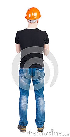 Backview of an engineer in construction helmet stands. Stock Photo