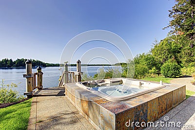 Backyard area with hot tub and awesome water view. Stock Photo