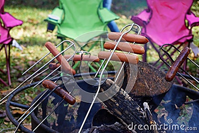 Backyard camping cooking hot dogs over a fire pit Stock Photo