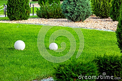 Backyard with 2 electric ground lanterns with sphere diffuser lamps. Stock Photo