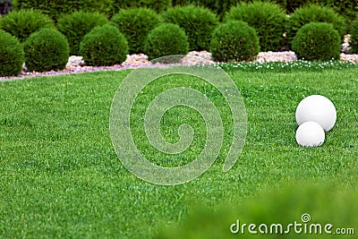 Backyard lights garden with 2 electric ground lanterns with sphere diffuser. Stock Photo