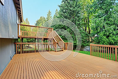 Backyard view of grey rambler house with upper and lower decks Stock Photo