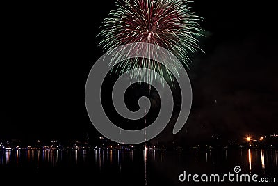 The fireworks paint the sky in various colors and are reflected in the Miseno lake, creating a breathtaking panorama. Stock Photo