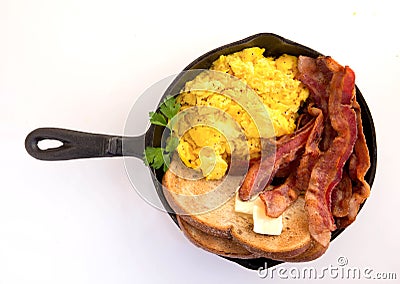 Bacon,scrambled eggs and toast in cast iron skillet white backgorund Stock Photo