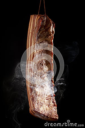 Bacon in smoke on dark background Stock Photo