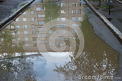 The bad asphalted road with a big pothole filled with water. Dangerous destroyed roadbed. Stock Photo