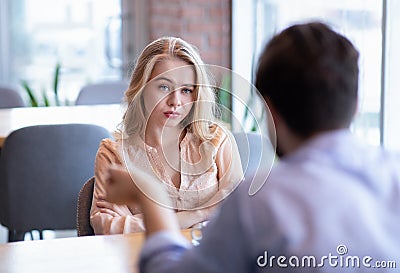 Bad date. Young woman feeling bored during dinner at cafe, unhappy with her boyfriend, disinterested in conversation Stock Photo