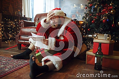 Bad drunk Santa claus reads letters, nasty man Stock Photo