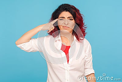 Bad idea. Portrait of disappointed unhappy woman in white shirt making stupid dumb cuckoo gesture Stock Photo