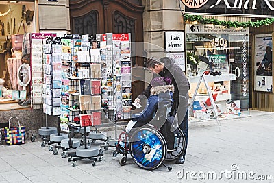 Dad with his daughter in a wheelchair on a street in Bad Kissingen, Germany Editorial Stock Photo