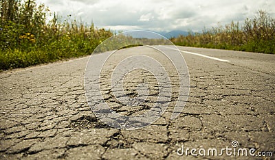 Bad road cracked and damaged. Stock Photo