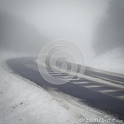 Bad weather driving - foggy hazy country road. Motorway - road traffic. Winter time. Autumn - fall. Snow and frost on the road in Stock Photo