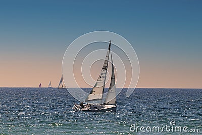 Sunset at sea and a sailboat sailing. Editorial Stock Photo