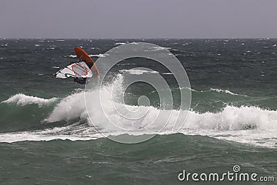 Windsurfer makes a jump in the air. Editorial Stock Photo