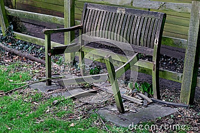 Badly damage commemorative park seat. Stock Photo