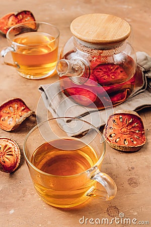 Bael fruit juice or quince tea and dried bael sliced fruit on rustic background. Thai or Asian healthy drink. Bael is helping the Stock Photo