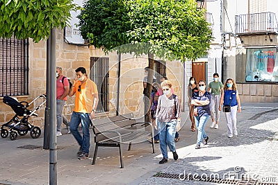 Baeza, Jaen, Spain - June 20, 2020: A group of unknown tourists with a professional tourist guide visiting the old city of Baeza Editorial Stock Photo