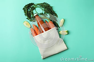 Bag with bottle of apple - carrot juice and ingredients on mint background Stock Photo